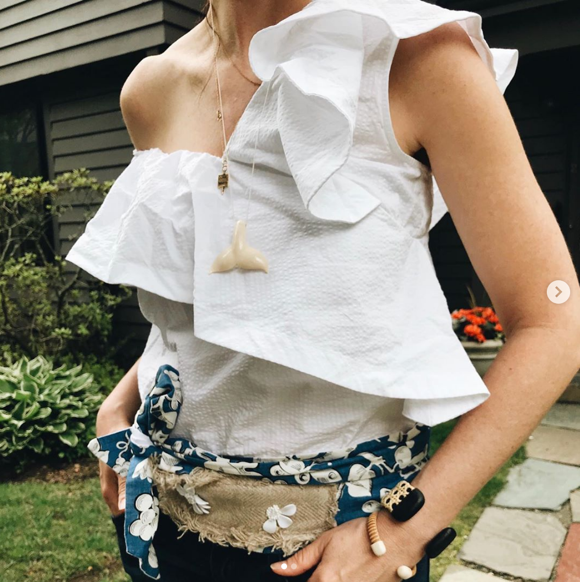 Woman in a white, ruffled shirt wearing a Whale Tail pendant and Nantucket bracelet cuffs.