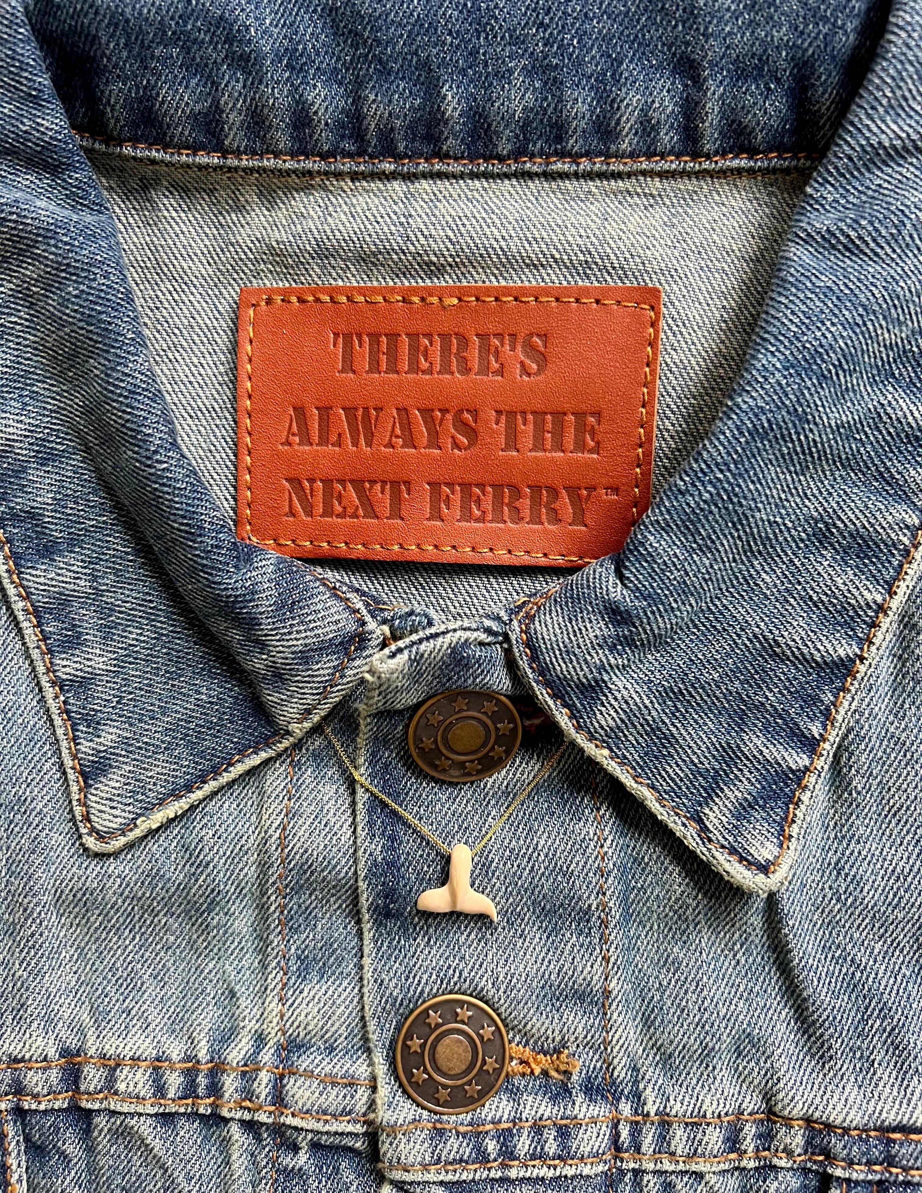 Close up of interior of jean jacket brown tag. 